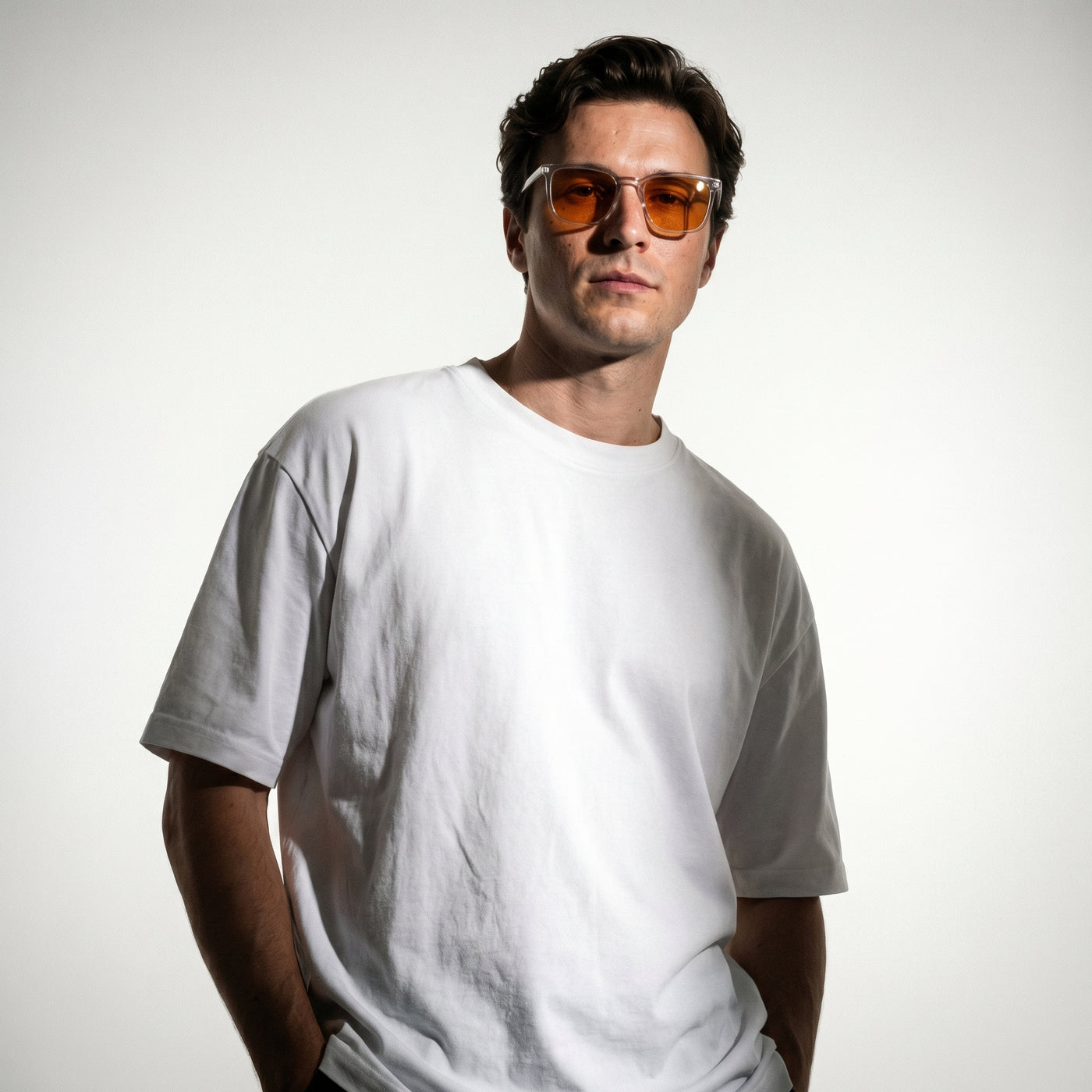 Studio portrait of a man in a white t-shirt wearing Skopos amber focus glasses