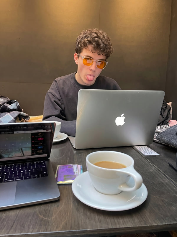 Man working late at a desk with coffee wearing Skopos amber focus glasses