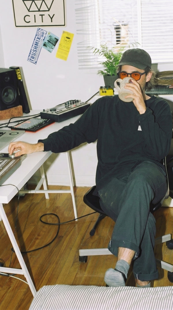 Man drinking coffee at a desk wearing Skopos amber focus glasses